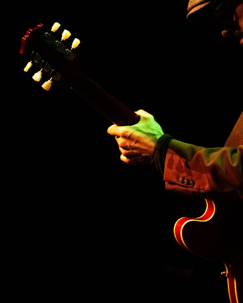 Fotografia de pormenor de mão de guitarrista de Peter Storm & The Blues Society no Quartel das Artes, Oliveira do Bairro, Aveiro, em 2025. Fotografia de A Patricia das Fotos, XPECTRUM.