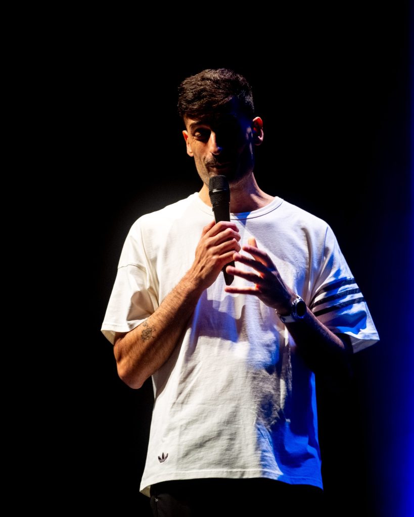António Raminhos em palco no Hu'morde-me, no Quartel das Artes, em Oliveira do Bairro, Aveiro, em 2025. Fotografia de A Patricia das Fotos, XPECTRUM.