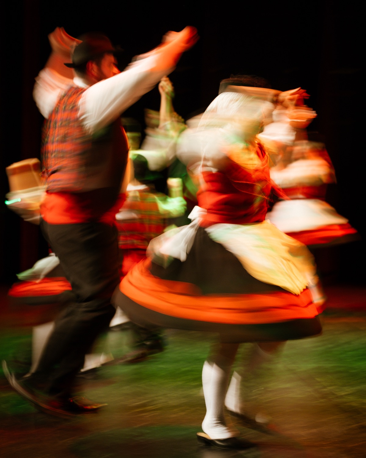 Casal de rancho folclórico em dança tradicional portuguesa captado com longa exposição transmitindo energia e movimento no evento MOB 2025 no Quartel das Artes