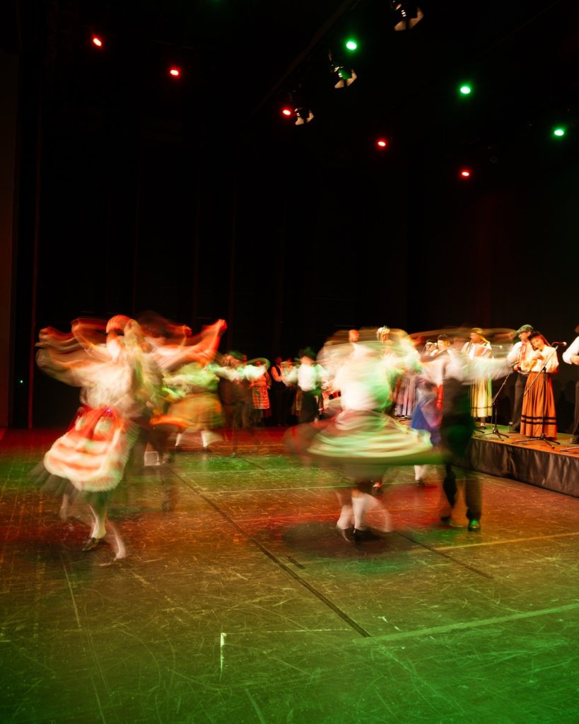 Grupo de rancho folclórico a dançar em palco iluminado a verde captado com longa exposição no evento MOB 2025 no Quartel das Artes