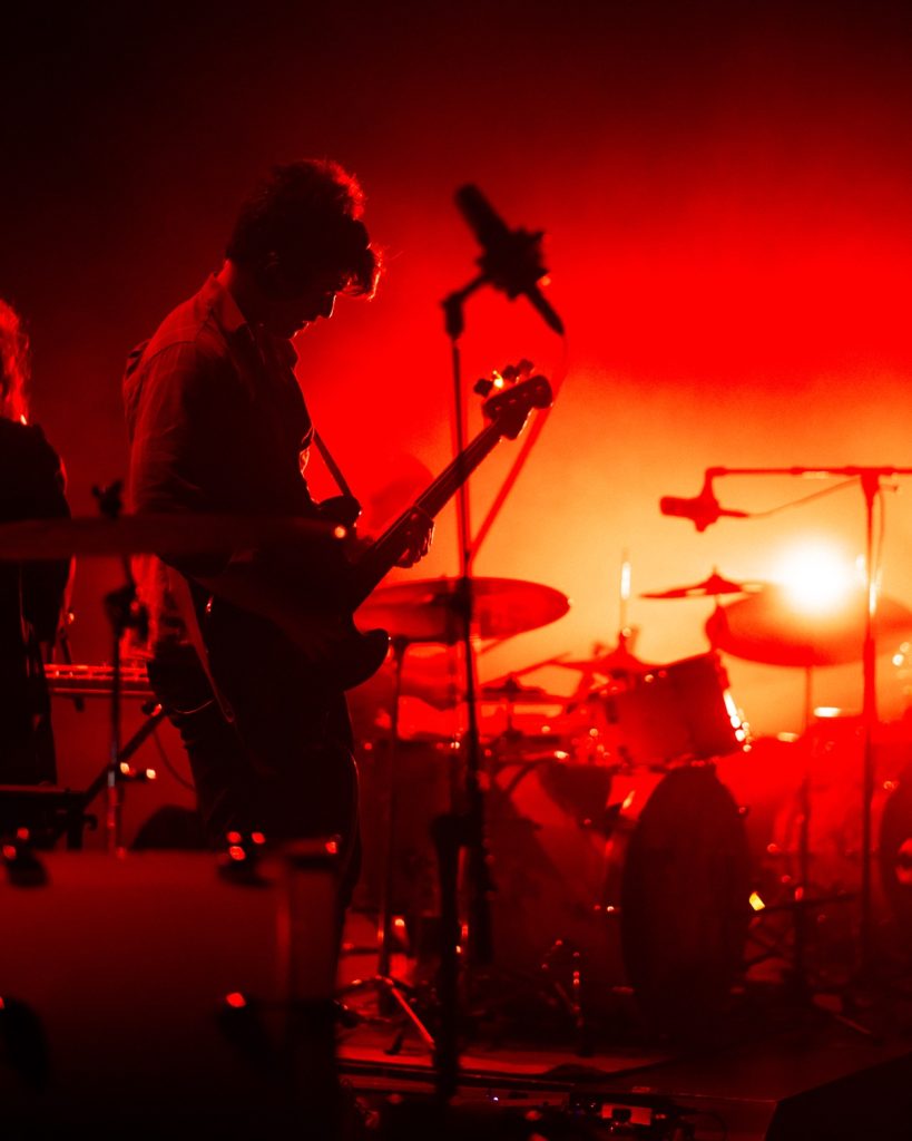 Sangue Suor ao vivo no Quartel das Artes 2025 – guitarrista em silhueta com luz vermelha – fotografia de concertos xpectrum