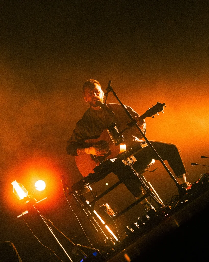 Diogo Piçarra a tocar guitarra acústica em palco com luz quente no Soam as Guitarras 2026, Quartel das Artes