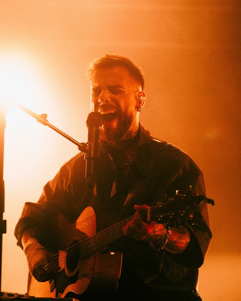 Diogo Piçarra a cantar intensamente com guitarra acústica no Soam as Guitarras, Quartel das Artes 2026