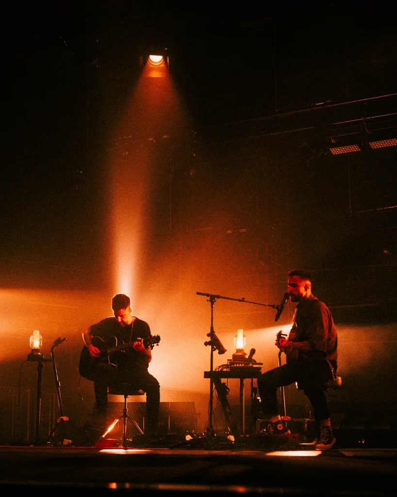 Diogo Piçarra com banda sob feixe de luz alaranjada no Soam as Guitarras 2026, Quartel das Artes