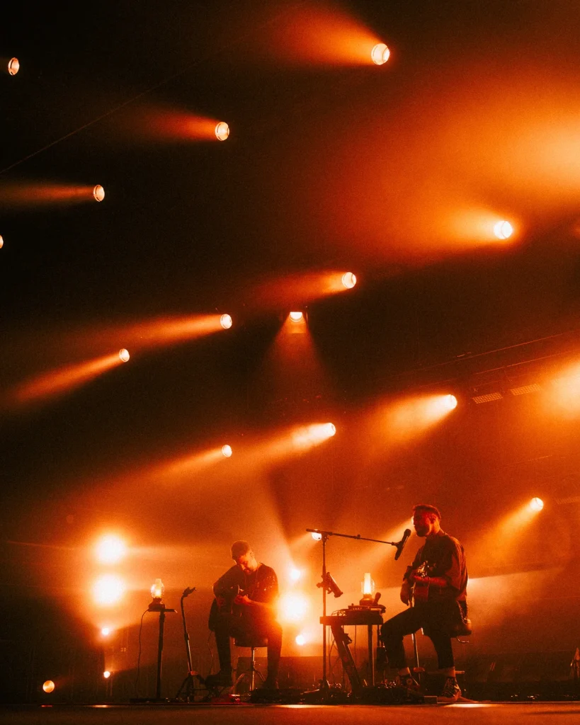 Plano aberto de Diogo Piçarra e Xico Aragão em palco com luzes diagonais no Soam as Guitarras 2026, Quartel das Artes