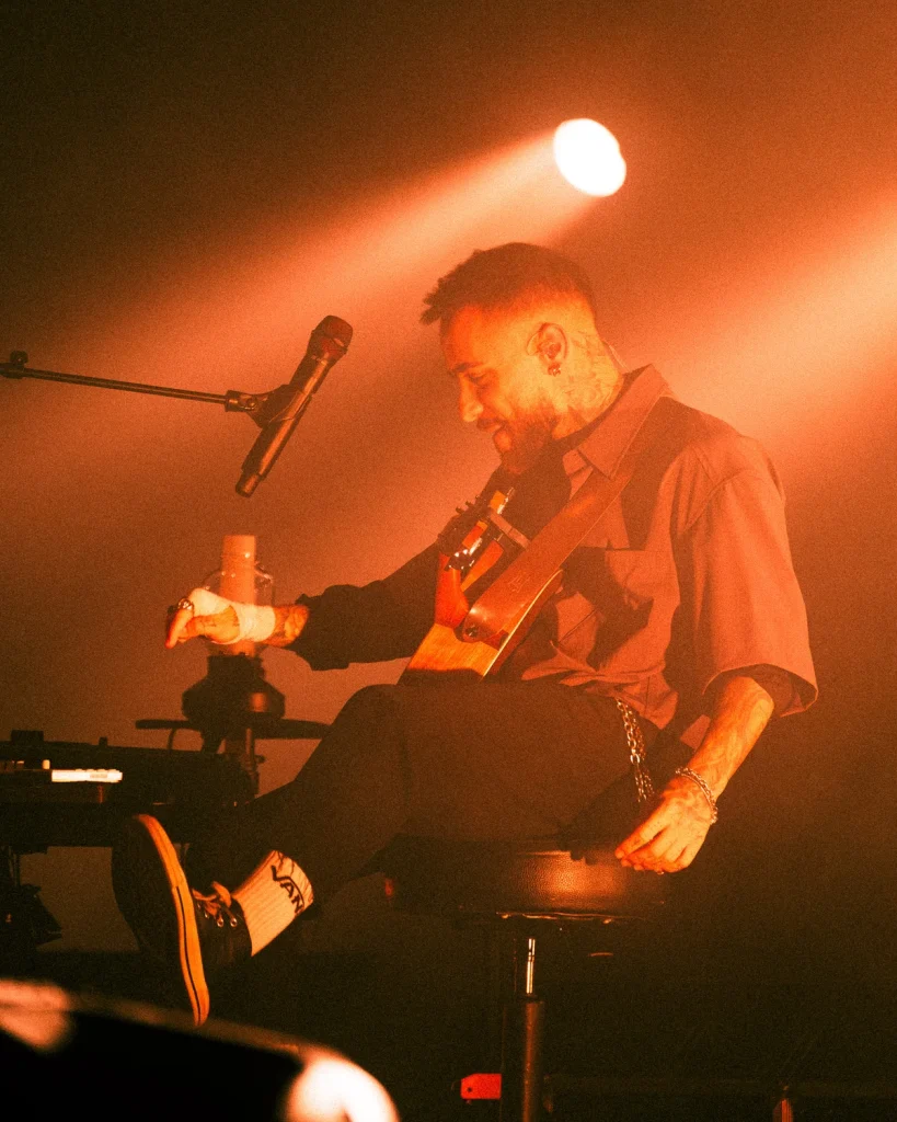Diogo Piçarra sentado a sorrir enquanto toca guitarra no Soam as Guitarras 2026, Quartel das Artes