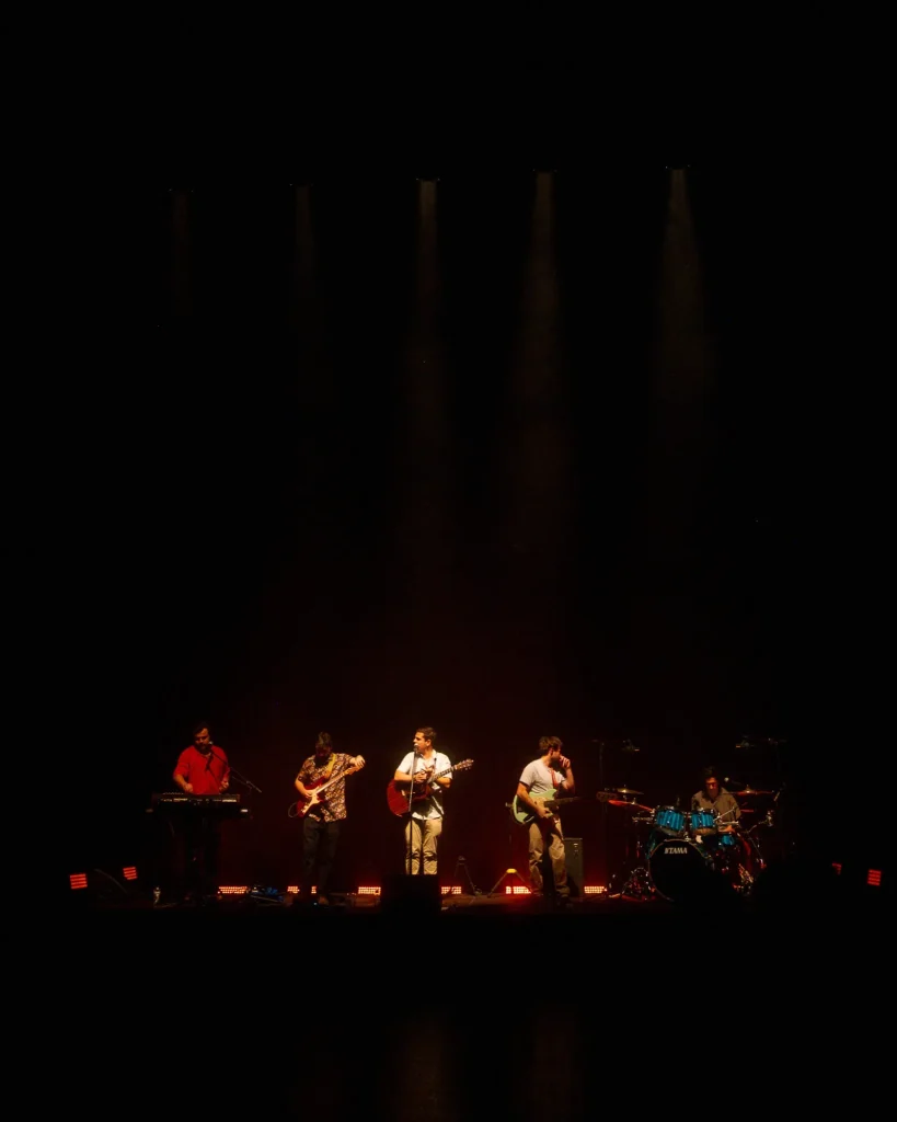 Plano largo dos Duque Província com cinco elementos no palco sob feixes verticais de luz no Quartel das Artes em 2025, fotografia de concertos xpectrum.