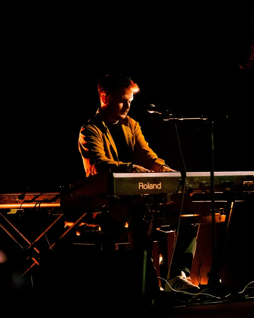 Diogo dos Equinócio a tocar teclado Roland iluminado por luz quente de palco no Quartel das Artes 2025