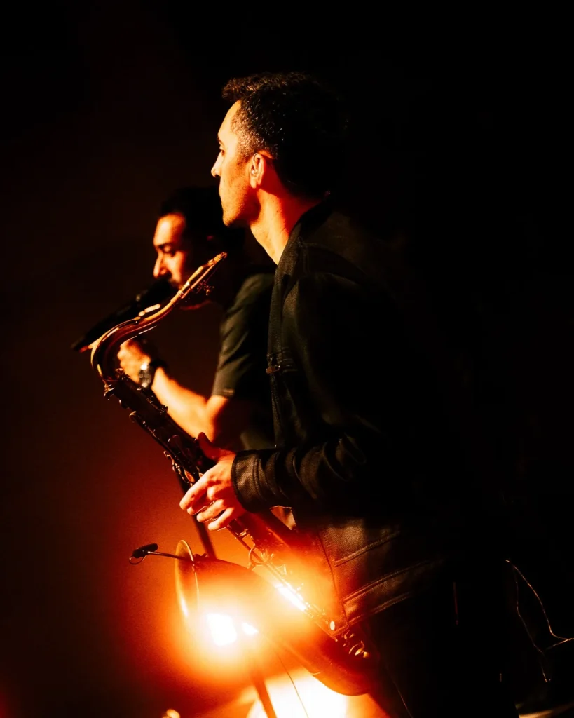 Saxofonista dos Tributus em palco banhado a laranja — concerto tributo a Pink Floyd no Quartel das Artes, 2025