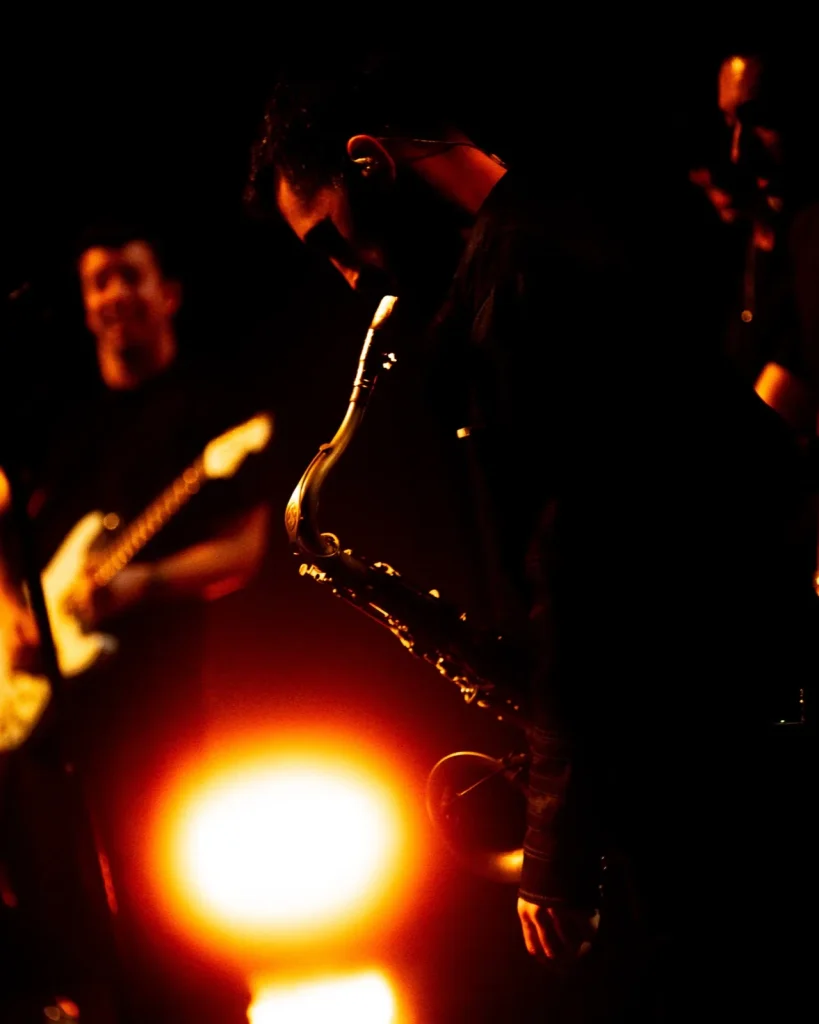 Saxofone dos Tributus em primeiro plano com guitarrista ao fundo — concerto tributo a Pink Floyd no Quartel das Artes