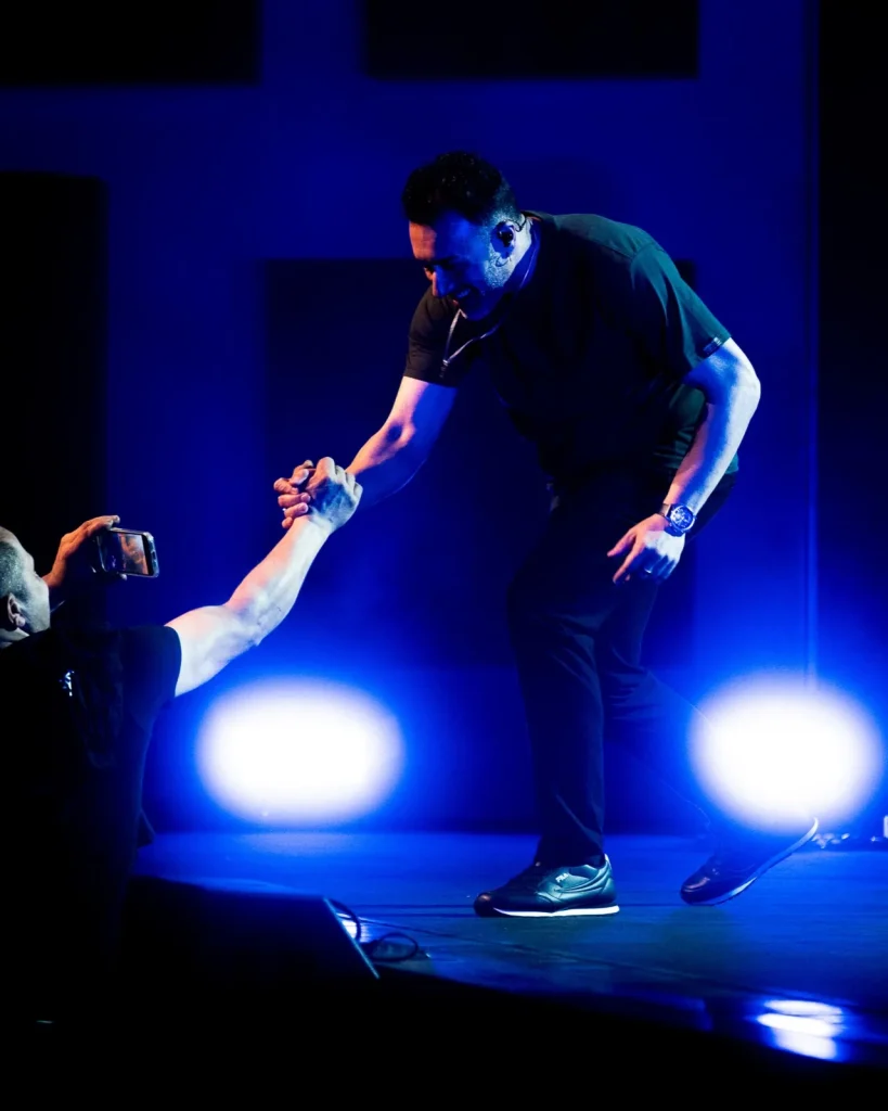 Vocalista dos Tributus cumprimenta fã da plateia em palco azul — concerto tributo a Pink Floyd no Quartel das Artes