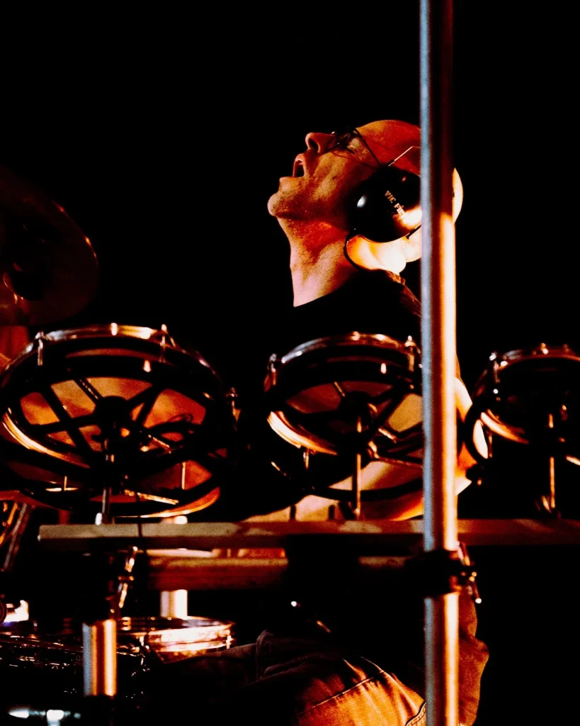 Baterista dos Tributus entre toms a olhar para cima sob luz quente — concerto tributo a Pink Floyd no Quartel das Artes